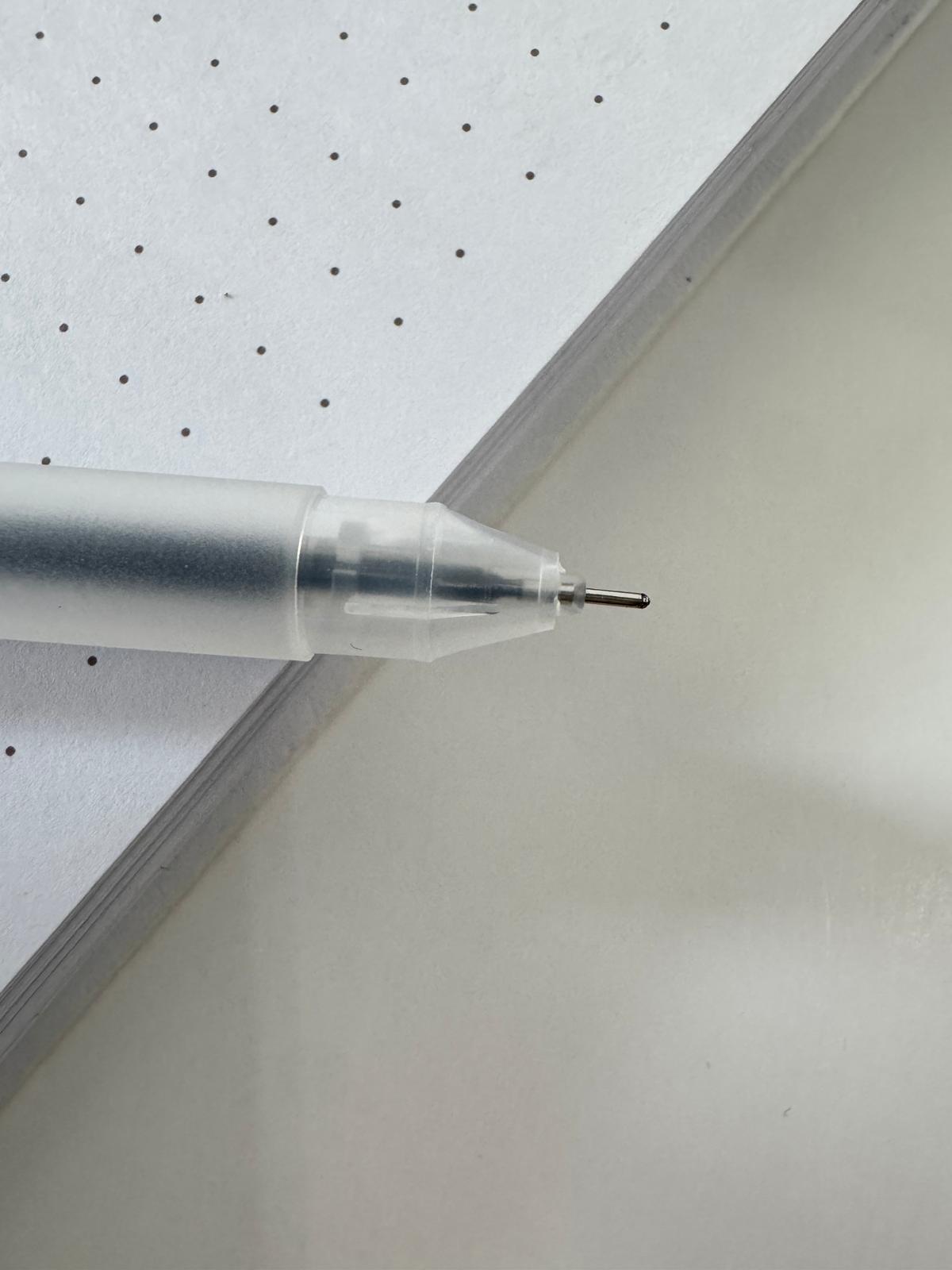 Clear barrel gel pen on journal with cap off