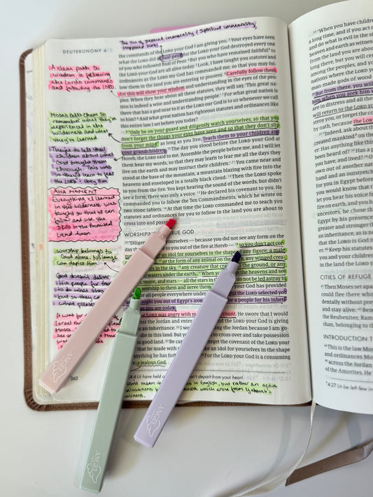 Bible open to Deuteronomy with pink, green, and purple bible-safe highlighters laying on top. - Angel Paper Co.